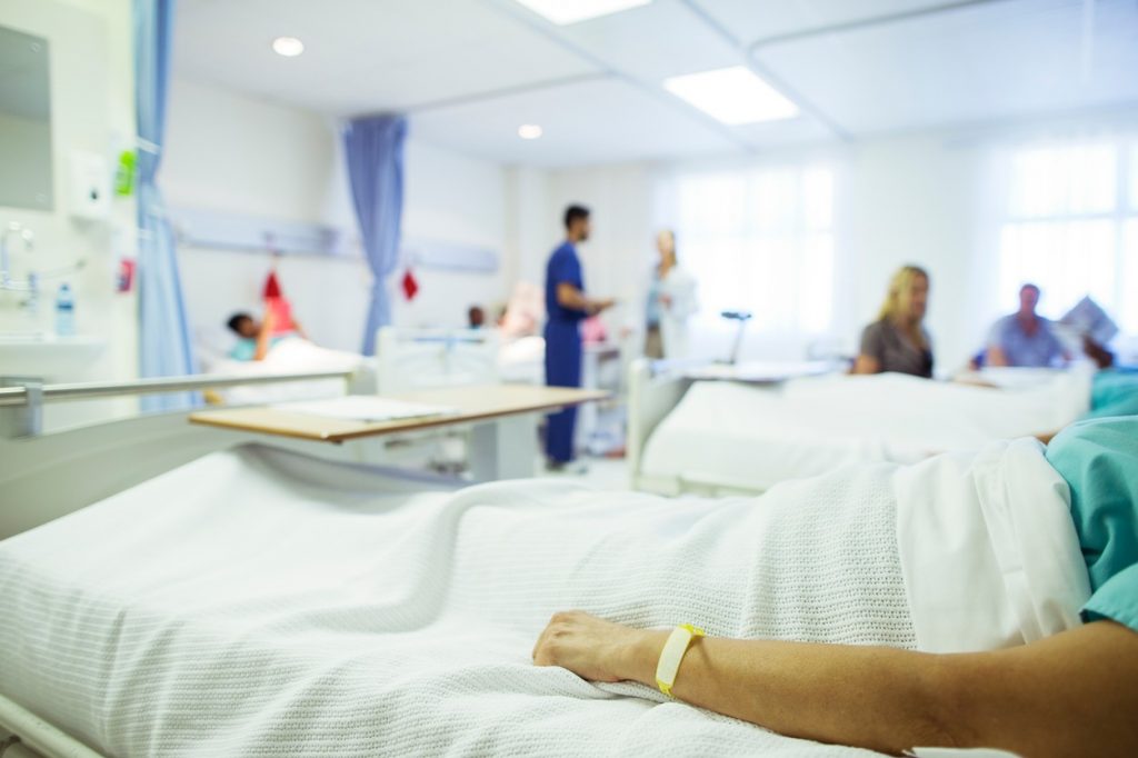 Bărbat întins pe patul de spital așteptând transplant