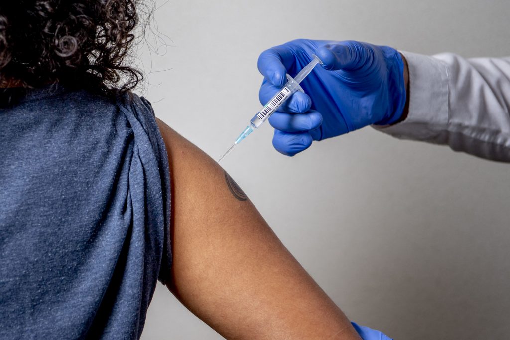 Medic care vaccinează o femeie.